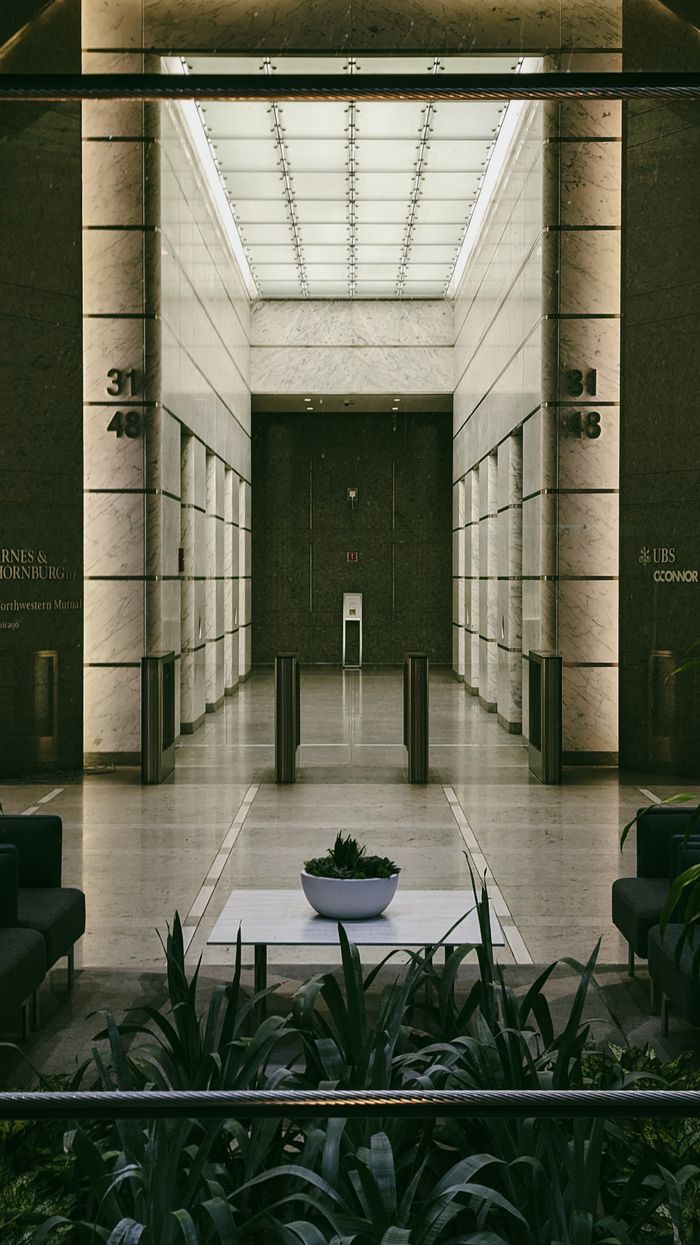 about-01 Spacious modern lobby with sleek design in Chicago. Features potted plants and architectural elements.